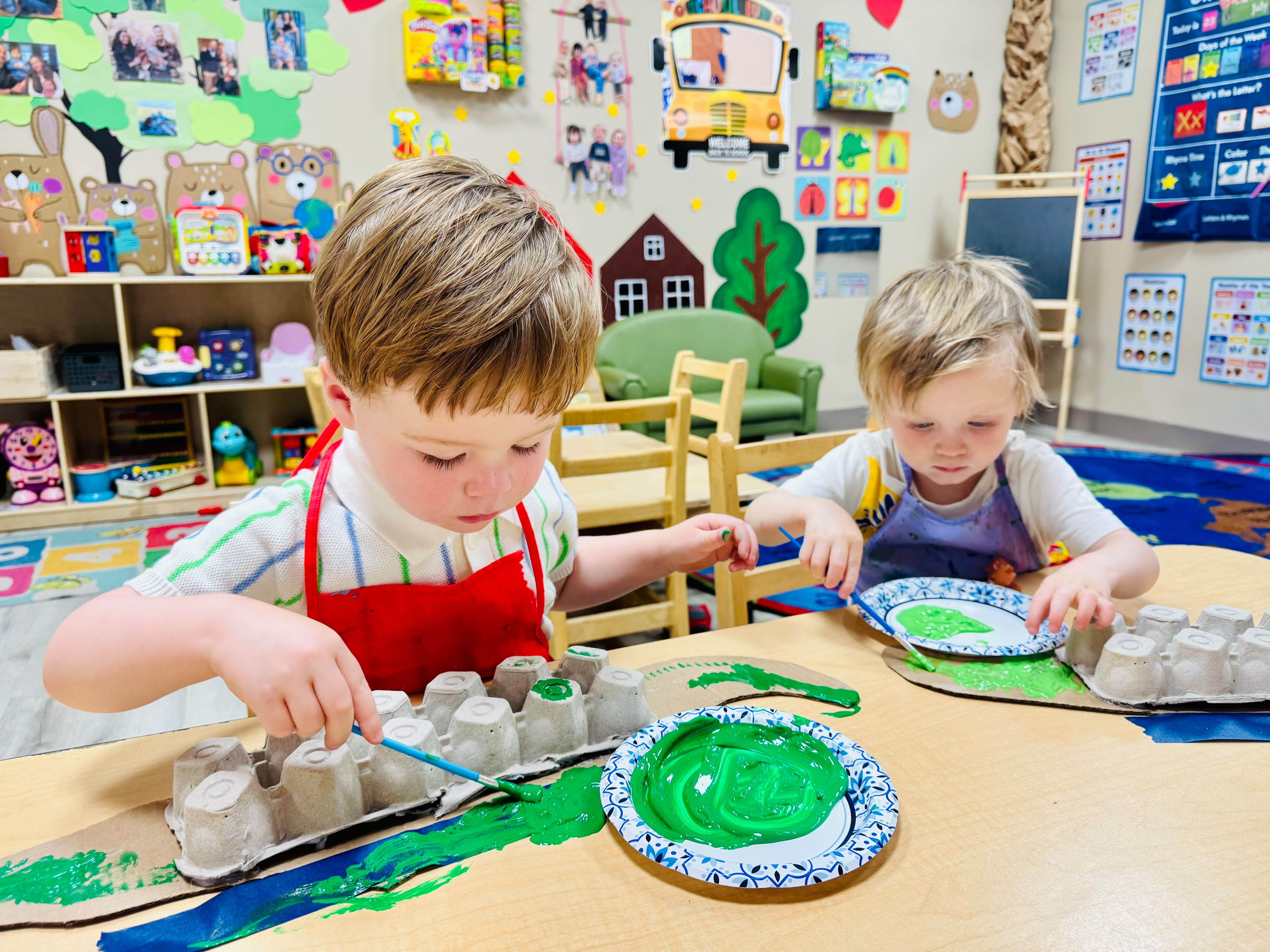 Two preschool children painting and creating together in a Global Children School classroom